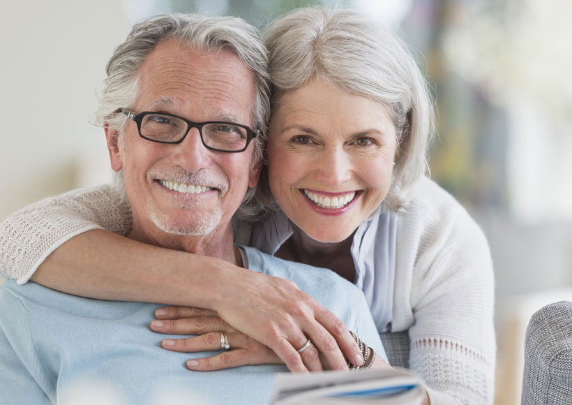 Smiling adult patient showing off restored smile after dental implant treatment